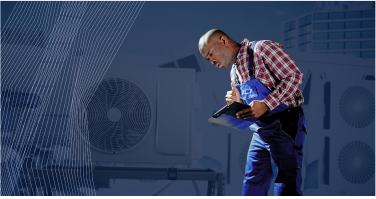 A technician in a plaid shirt and overalls examines a clipboard with a large industrial fan and abstract lines in the background.